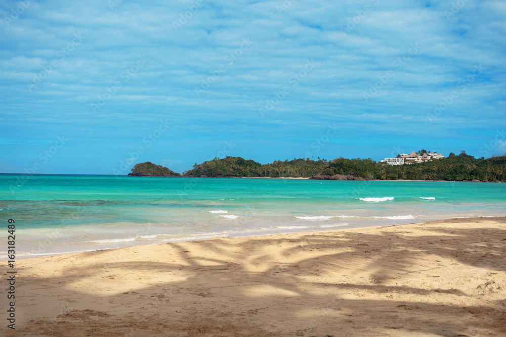 Caribbean beach. Azure caribbean sea and sandy beach on background of green islands