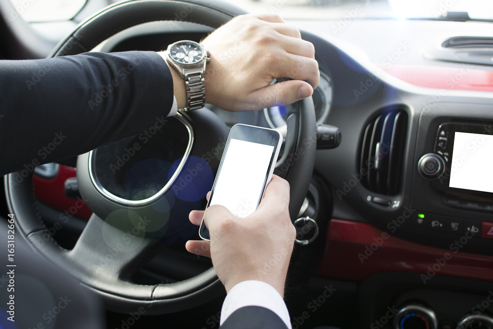 Close-up of a man's hand holding a smartphone. Businessman texting while sitting in a car. Holding a steering wheel and using a mobile phone. Close-up of a man's hand holding a smartphone. Businessman texting while sitting in a car. Holding a steering wheel and using a mobile phone.