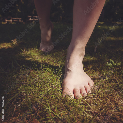 Female barefoot legs walking in nature photo