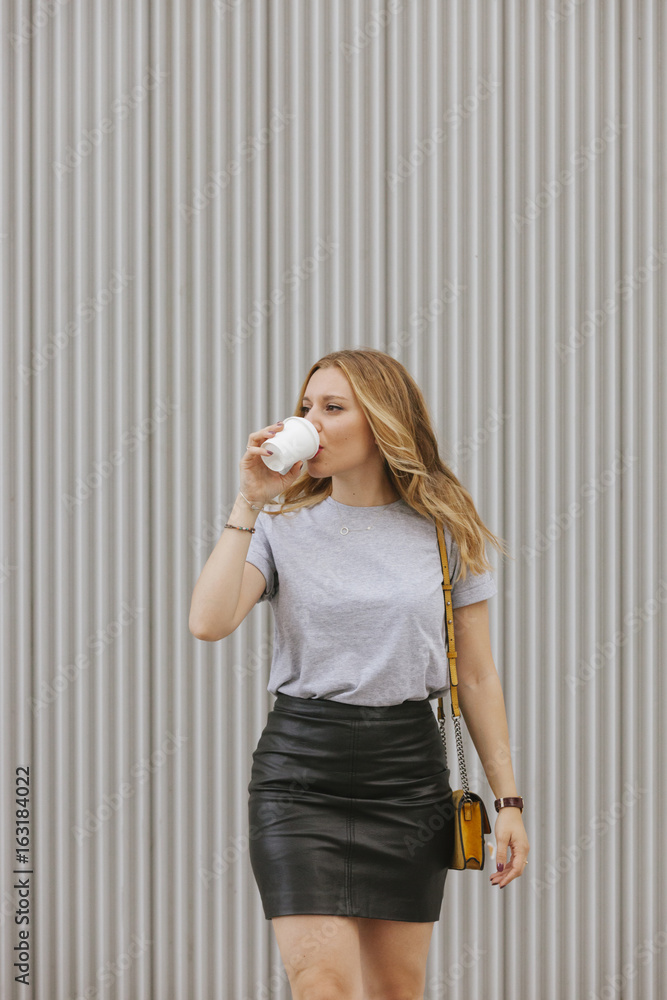 sexy blonde woman drinking coffee walking on the street sexy blonde woman drinking coffee walking on the street