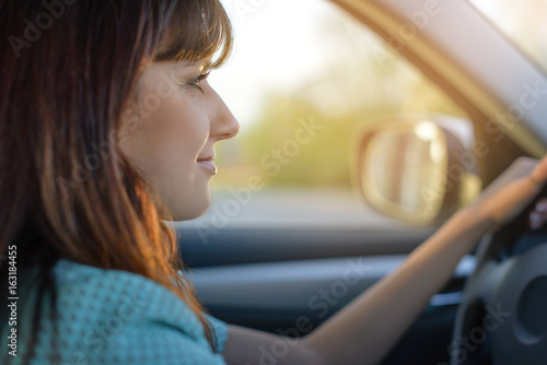 beautiful brunette drives a car. woman driving: risk or myth.