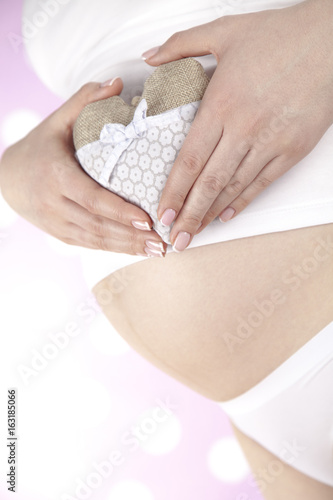 Pregnant woman holding a heart © Sebastian Duda