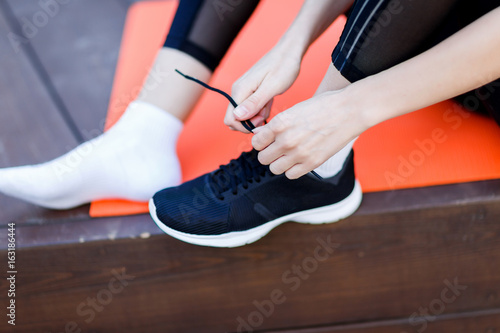 Athlete ties shoelaces on sneaker