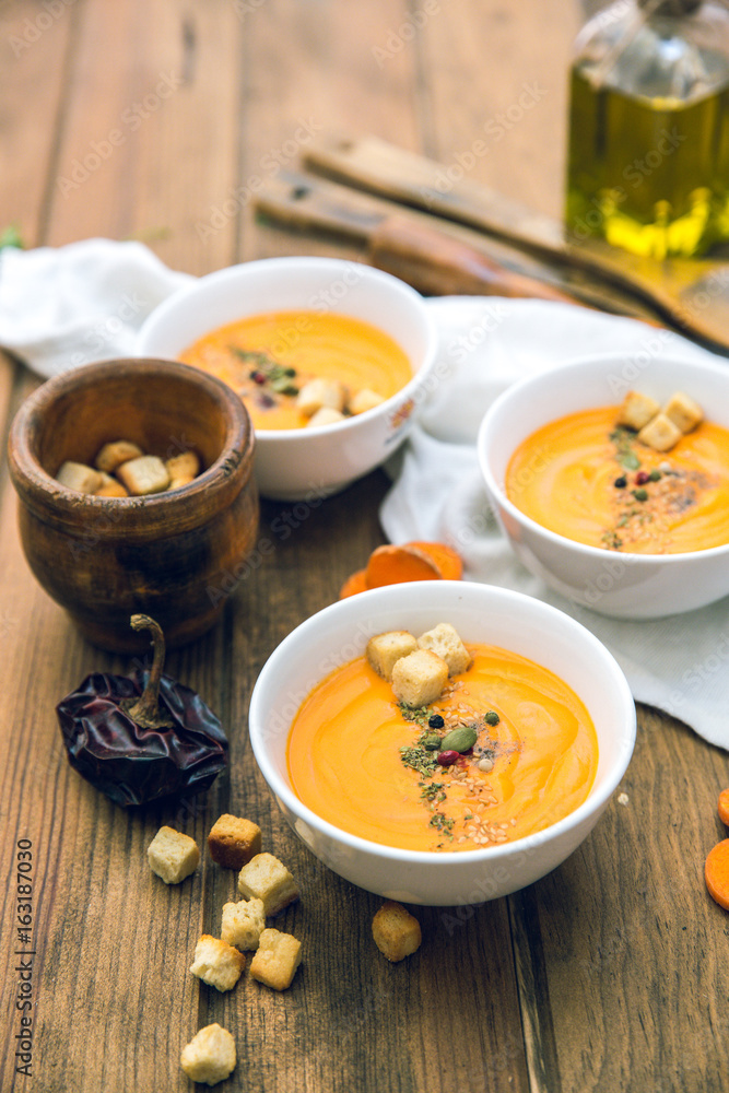 Soup with sweet potatoes, carrots, pumpkin on wooden background Soup with sweet potatoes, carrots, pumpkin on wooden background