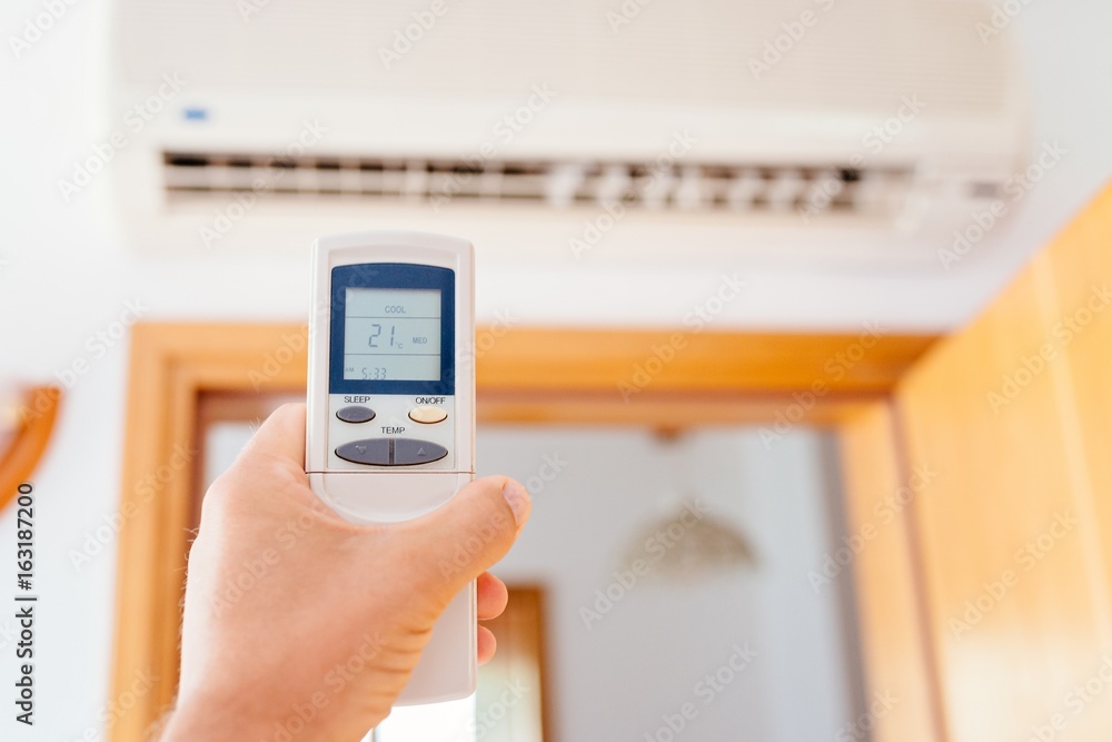 Close up on male hand adjusting home air condition Close up on male hand adjusting home air condition