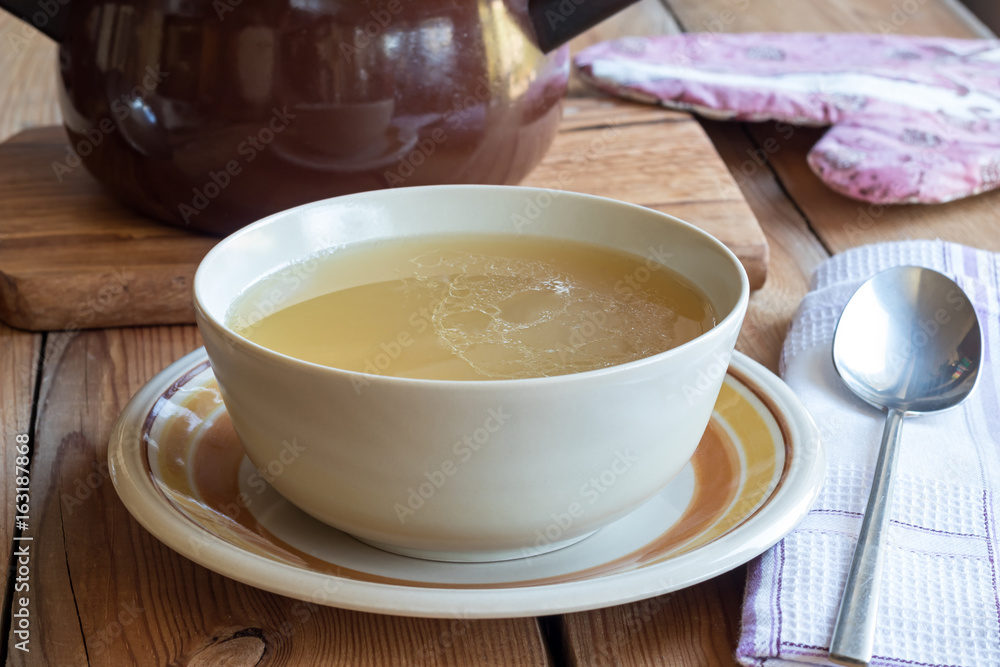Bone broth made from chicken served in a soup bowl Bone broth made from chicken served in a soup bowl