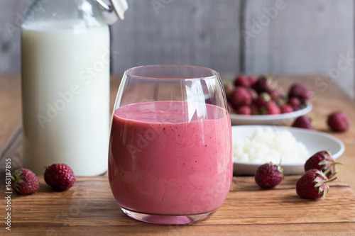 Homemade kefir with strawberries on a wooden background photo