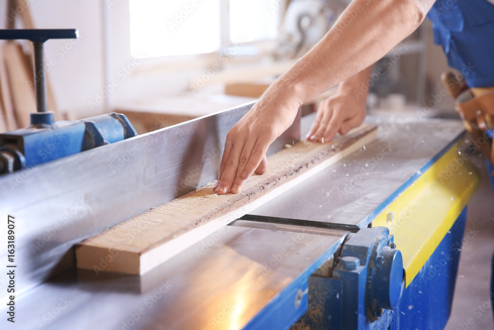 Carpenter working with timber in shop Carpenter working with timber in shop