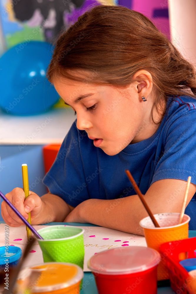 Small students painting in art school class. Child drawing by paints on