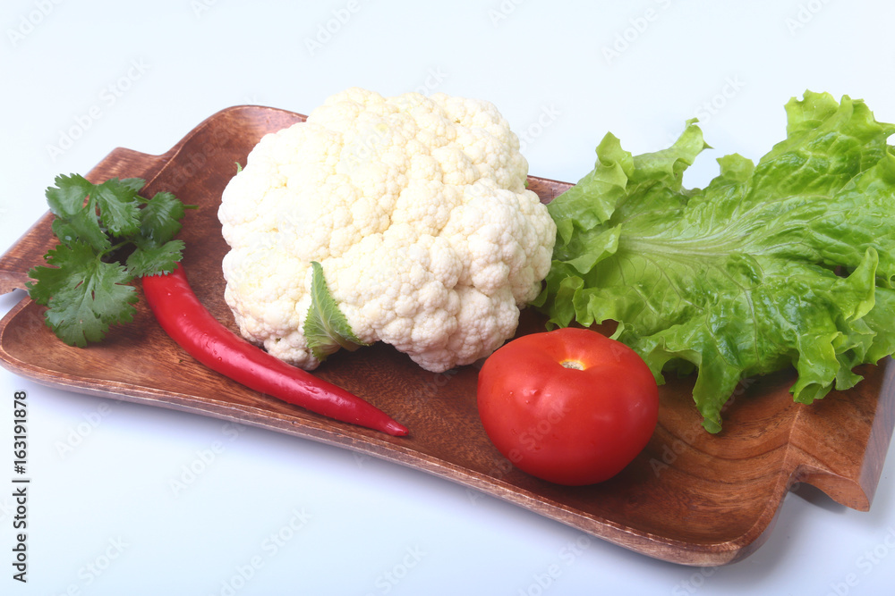 fresh cauliflower, tomato, salad leaves and other vegetables on wooden board. Ready for cooking. Vegetarian food. fresh cauliflower, tomato, salad leaves and other vegetables on wooden board. Ready for cooking. Vegetarian food.