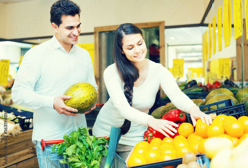 Fototapeta premium couple buying fresh seasonal fruits in market