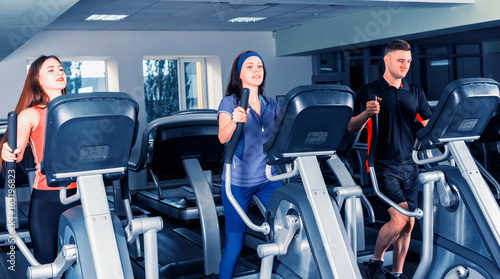 Group of people diligently exercising on the crosstrainer machines photo