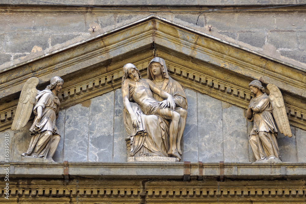 Sculpture of La Pieta by Michelangelo Naccherino in the typanum above the entrance of the Chapel of Monte di Pieta - Naples, Campania, Italy