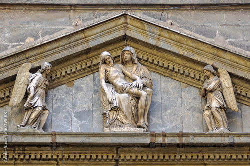Sculpture of La Pieta by Michelangelo Naccherino in the typanum above the entrance of the Chapel of Monte di Pieta - Naples, Campania, Italy photo