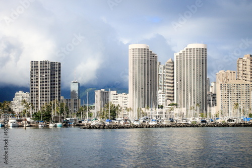 Honolulu, Hawaii, USA - May 30, 2016: Yachts docked at Ala Wai Boat Harbour in the Kahanamoku Lagoon against cityscape of Ala Moana.