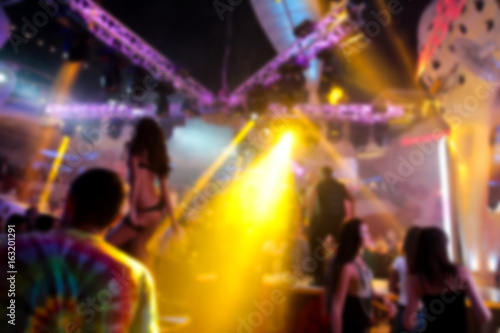 Blurry night club dj party people enjoy of music dancing sound with colorful light. club night light dj party Ibiza club. With Smoke Machine and lights. Dark background.