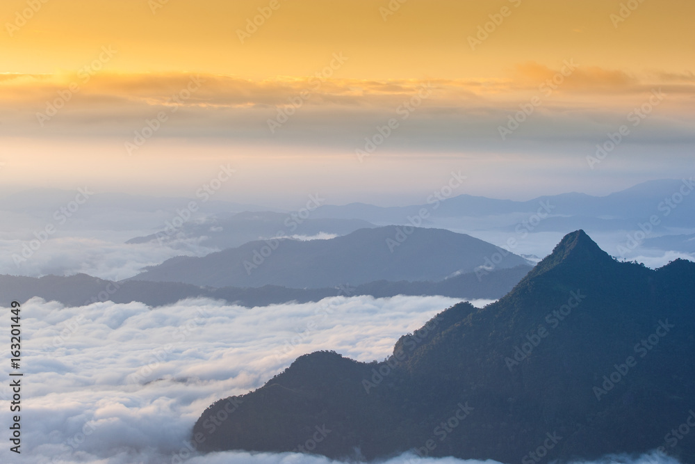 The beautiful landscape of mountain range with visible silhouettes through the morning colorful fog of Phu Chi Fa National Park, Chiang Rai Province, Thailand. The beautiful landscape of mountain range with visible silhouettes through the morning colorful fog of Phu Chi Fa National Park, Chiang Rai Province, Thailand.