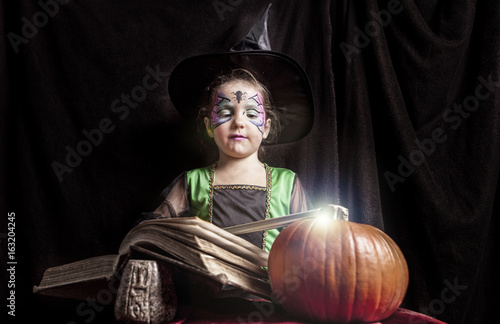 Little witch reads the Book of Spells