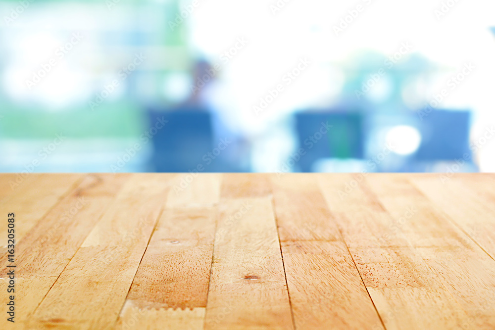 Wood table top on blur background of a person sitting in bright room Wood table top on blur background of a person sitting in bright room