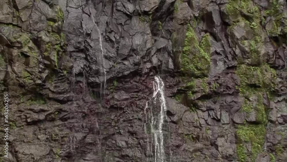 Zoom out from springs in mountain to waterfall on Kauai Zoom out from springs in mountain to waterfall on Kauai
