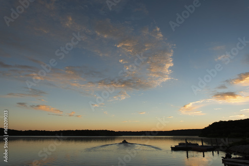 Fisherman going out on a lake just before sunrise