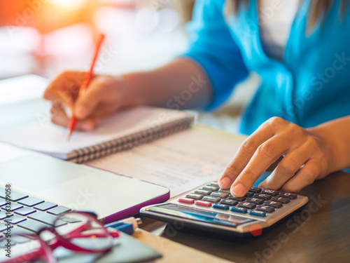 woman working with calculator, business document and laptop computer notebook