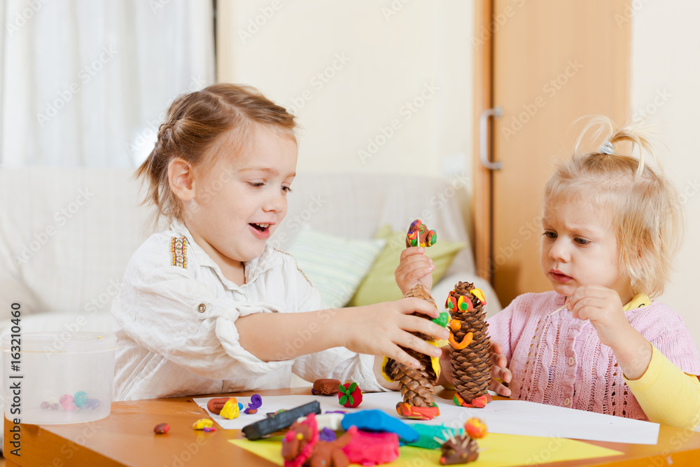 Fototapeta premium girls playing with plasticine at house