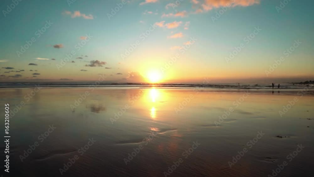 Sunset beach with wet sand reflecting the sky, Bali, Seminyak Sunset beach with wet sand reflecting the sky, Bali, Seminyak