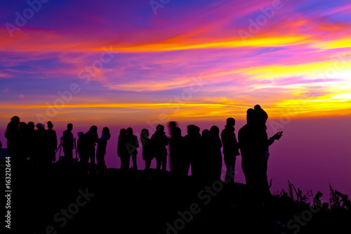 Group of people on top of a mountain waiting for take photo with light Twilight.