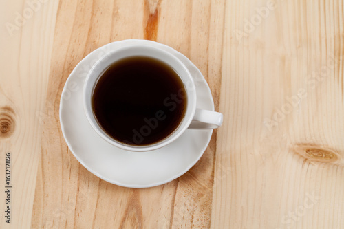  White Cup of coffee on Pine wood desktop table on top