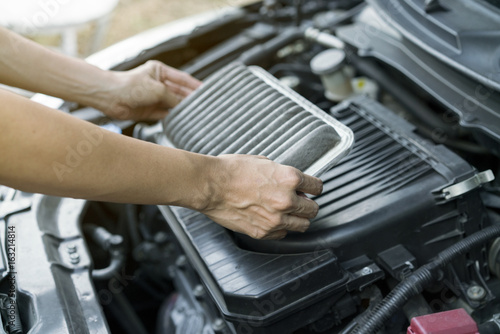 Technician holding dirty air filter for car, maintenance and repair concept