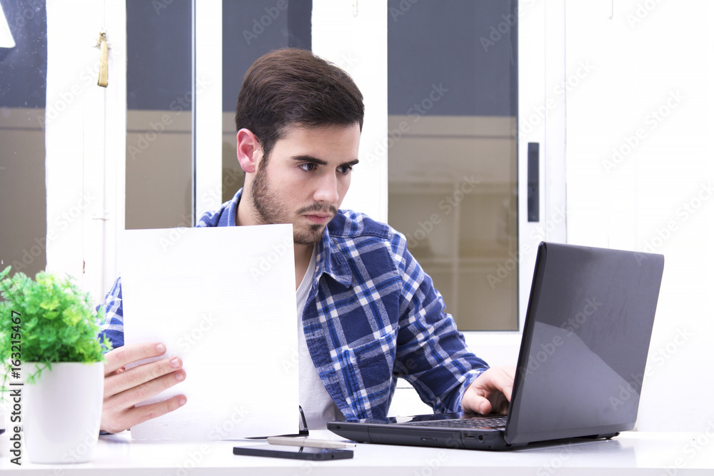 Young man in the office reading contract work Young man in the office reading contract work