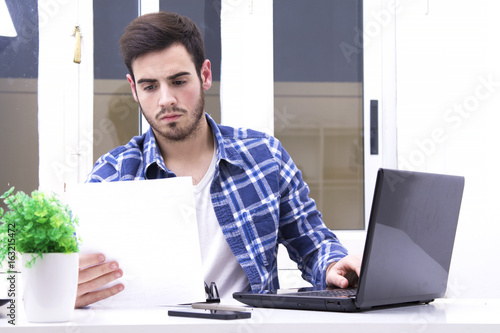 Young man in the office reading contract work photo