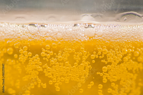Fotografija bubble beer close up / yellow background / water / drink