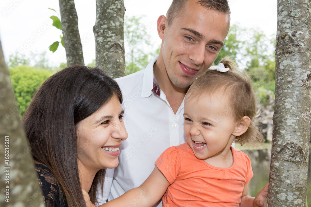 Happy mother, father and daughter in the park. Beauty nature scene with family outdoor lifestyle. Happy mother, father and daughter in the park. Beauty nature scene with family outdoor lifestyle.