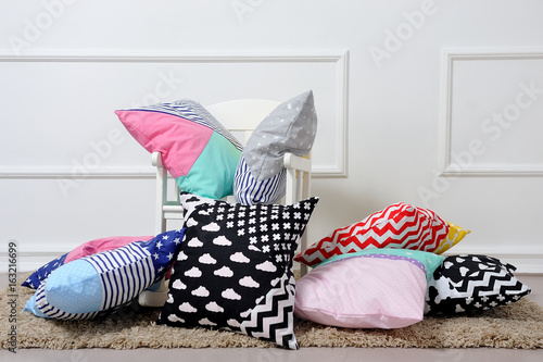 a lot of pillows lying next to the rocking chair photo