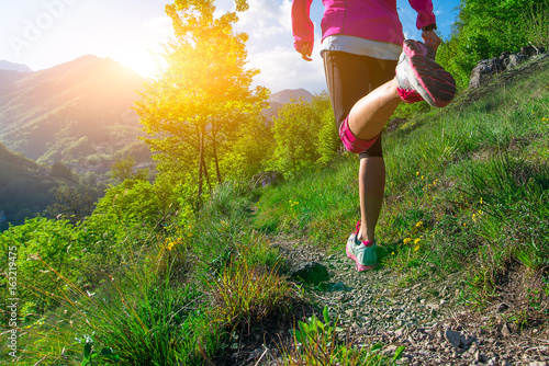 Detail of the legs of a girl running on a mountain trail