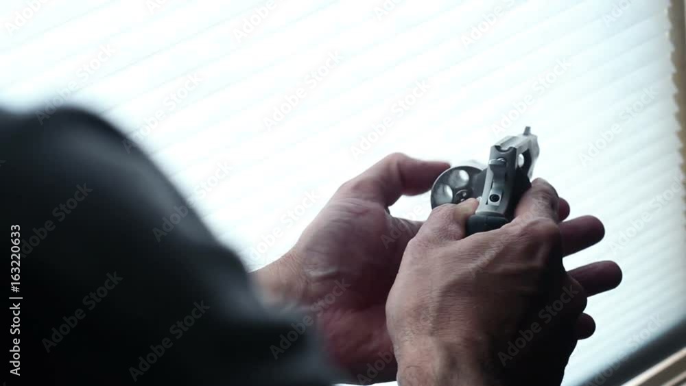 Man makes sure his revolver is unloaded inside - reverse angle Man makes sure his revolver is unloaded inside - reverse angle
