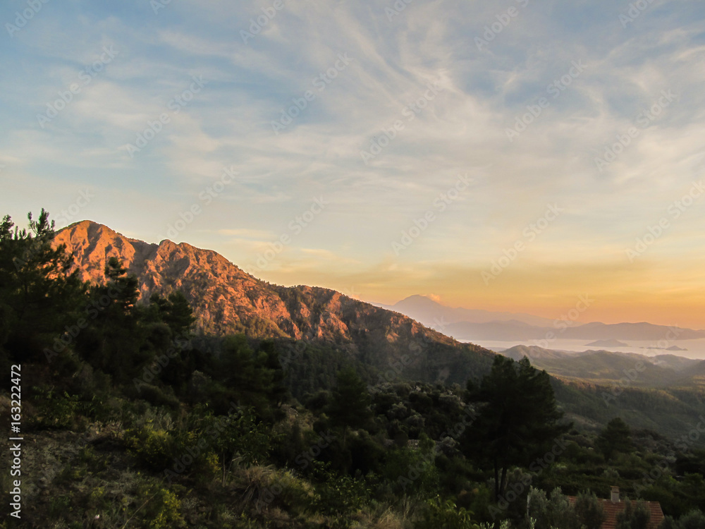 Sunset view from the mountains in Gocek, Turkey - beach town of Fethiye below Sunset view from the mountains in Gocek, Turkey - beach town of Fethiye below