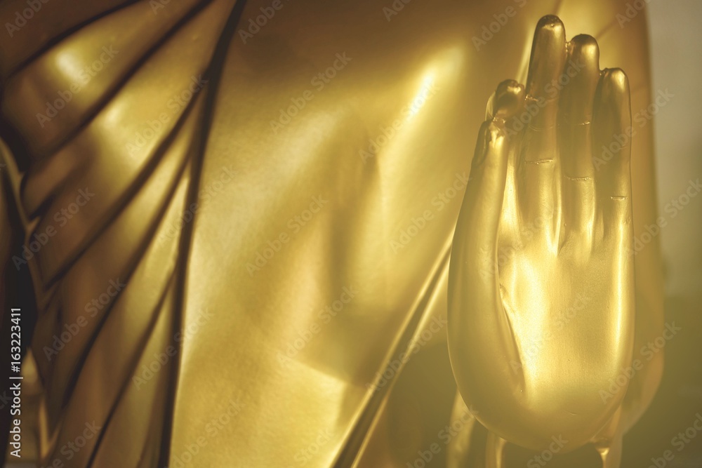 Close up Hand of Golden Buddha Image with Light Leak.