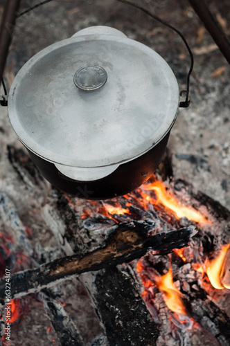 Hiking pot in the bonfire. Traveling in the mountains with tents