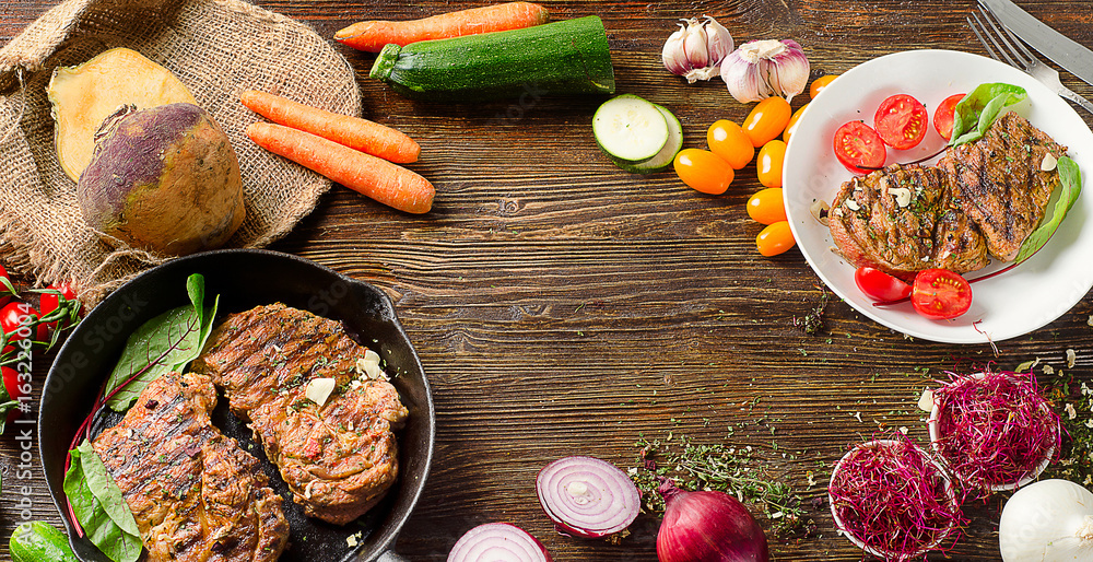 Roasted steaks in pan on a dark wooden table. Roasted steaks in pan on a dark wooden table.