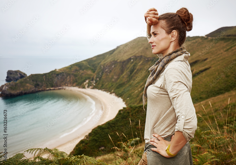 woman looking into distance in front of ocean view landscape