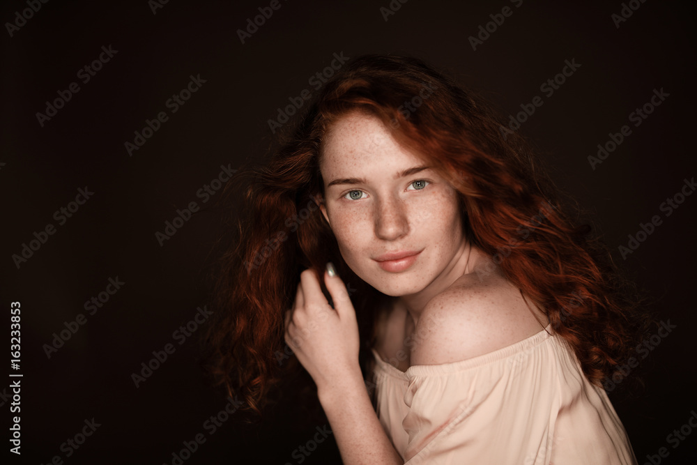 pretty sensual redhead woman posing in beige blouse, isolated on black with copy space pretty sensual redhead woman posing in beige blouse, isolated on black with copy space