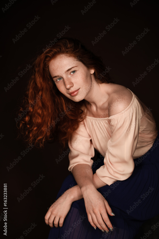 tender redhead woman posing in beige blouse for studio shot, isolated on black tender redhead woman posing in beige blouse for studio shot, isolated on black