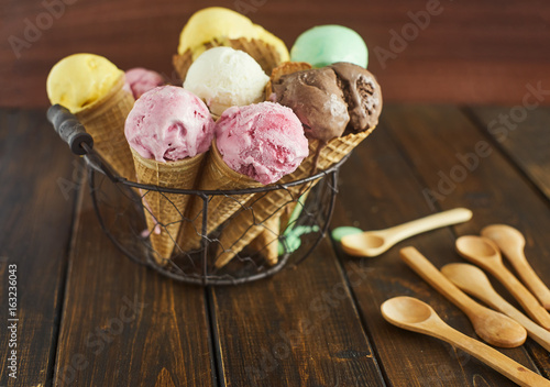 Many iice cream cones on wooden background photo