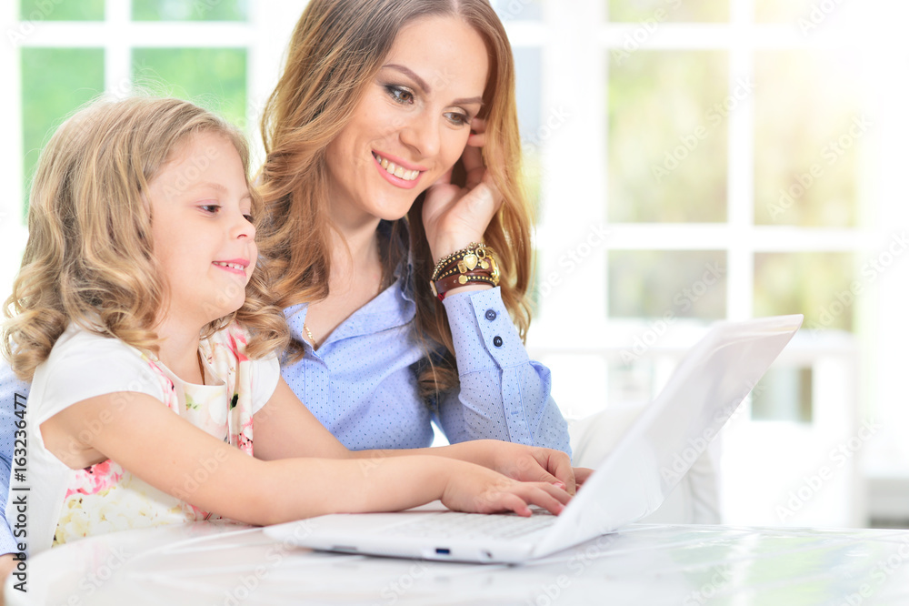 woman and little girl using laptop woman and little girl using laptop