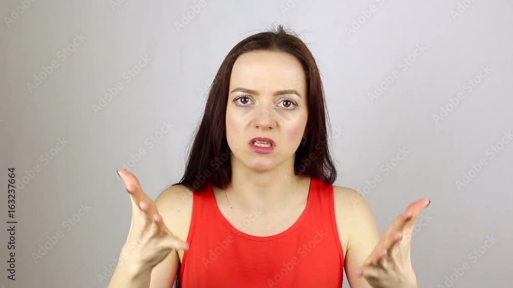 Young beautiful woman full of fury, looking at camera. Swears Young beautiful woman full of fury, looking at camera. Swears