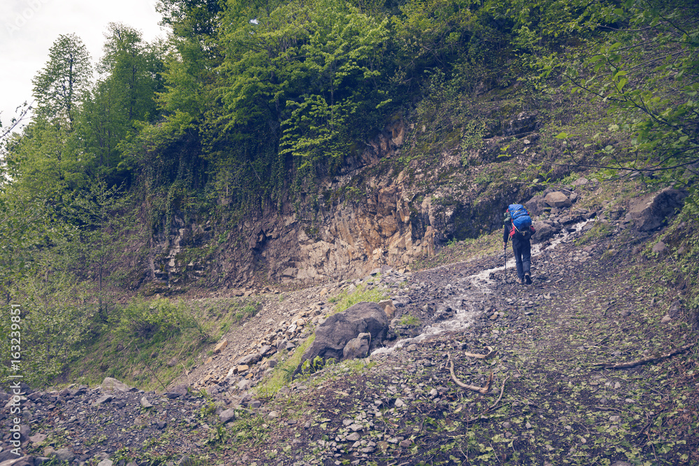 Man traveler with big backpack on a mountain road Man traveler with big backpack on a mountain road