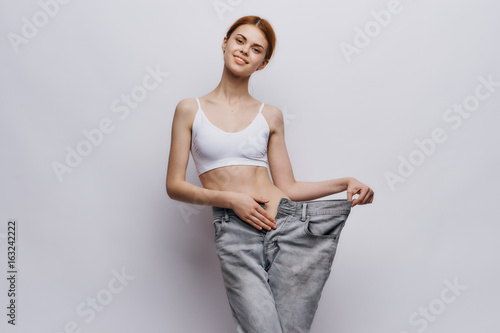 Beautiful young woman on a light background, losing weight, diet, progress, success